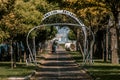 A modern archway over a bike lane street in Burgas. Tree leaves in yellow and orange autumn colours