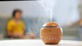 Modern aroma oil diffuser on the white table. Little boy in the background reading a book Royalty Free Stock Photo