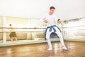 Modern art dancer teenager dressed in white clothes listening a music with smartphone using a headphones and dancing in mirror hal Royalty Free Stock Photo