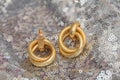 Modern asymmetrical golden earrings with layered rings Royalty Free Stock Photo