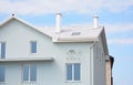 Modern attic house with white clay roof, blue walls, skylight window