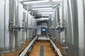 Modern automated beer factory. Lines of metal tanks in modern brewery. Shopfloor with brewery facilities. Manufacturable process o