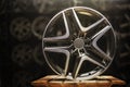 Modern automotive alloy wheel made of aluminum on a black background, industry. on a textured wooden table. Designer Royalty Free Stock Photo