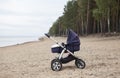 Modern baby stroller standing on empty sandy beach, side view Royalty Free Stock Photo