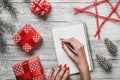 A modern background of a white background carnet background, and a young lady who writes a Christmas message with a white message. Royalty Free Stock Photo