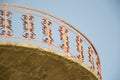 Modern red balcony, red openwork wrought iron fence with heart shapes against blue sky, railings, exterior of a building