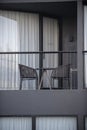 Modern balcony for a sweet resort hotel room with two outdoor seats and a round table. Royalty Free Stock Photo