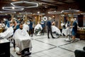 Modern barbershop. Professional barbers serving clients in the modern loft style barber shop. General view. Hairdresser