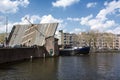 The modern barge on the river under the open bridge in Amsterdam