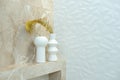 A modern bathroom in beige tones with marble tiles and a white textured wall, designer vases with dried flowers. Interior Design. Royalty Free Stock Photo