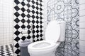 Modern bathroom design featuring artistic wall patterns and checkerboard tiles. Royalty Free Stock Photo