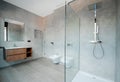 Modern bathroom with a glass bathtub and luxury washbasin. The walls and floor are covered with modern tiles