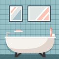 Modern bathroom interior with bathtub, pictures, soap and dispensers