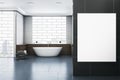 Modern bathroom interior with blank mock up poster on wall, bathtub, abstract windows and reflections on concrete flooring. Royalty Free Stock Photo