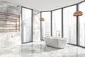 Modern Bathroom interior in new luxury home. Stylish hotel room. Open space area. Marble walls and floor. White bathtub Royalty Free Stock Photo