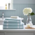 Modern bathroom interior, pile of clean towels and toiletries, white walls, sunny day Royalty Free Stock Photo