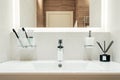 Modern bathroom interior with white sink and mirror. Toothbrushes, flavoring and liquid soap Royalty Free Stock Photo