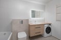 Modern Bathroom with Light Wood Accents and Washing Machine Royalty Free Stock Photo
