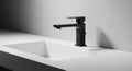 Black faucet with angular contemporary styling is mounted on the Royalty Free Stock Photo