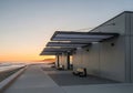 Modern Beachfront Architecture at Sunset, Coastal Walkway with Benches, Tranquil Evening Scenery Royalty Free Stock Photo