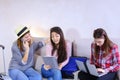 Three young women sisters use gadgets and communicate with each Royalty Free Stock Photo