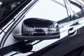 Modern beautiful side rear-view mirror in a new car with a built-in direction indicator. Black car at a car dealership, Royalty Free Stock Photo