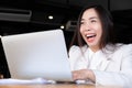 A modern beautiful and young Asian business woman using a laptop with happiness and smiling for success emotion in her office Royalty Free Stock Photo