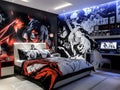 Modern bedroom with anime themed wallpaper, white bed frame and red and black bedding Royalty Free Stock Photo