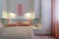 A modern bedroom in blue, pink and white colors with muffled lighting. Real photo Royalty Free Stock Photo
