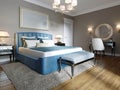 A modern bedroom in an eclectic style. With a double blue bed, black dressing table and chest of drawers with decor. beige walls Royalty Free Stock Photo