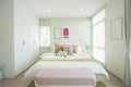 Modern bedroom with green and pink pillows on bed. Royalty Free Stock Photo