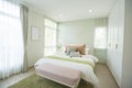 Modern bedroom with green and pink pillows on bed. Royalty Free Stock Photo