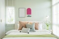 Modern bedroom with green and pink pillows on bed. Royalty Free Stock Photo