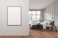 Modern bedroom interior with a blank white poster on the wall, wooden flooring, and city view background, concept of home decor. Royalty Free Stock Photo