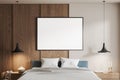 Modern bedroom interior featuring a large blank poster frame on a wooden wall, bed with pillows, pendants, and nightstand, concept Royalty Free Stock Photo