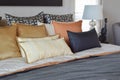 Modern bedroom interior with orange and gold pillows on bed Royalty Free Stock Photo