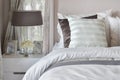 Modern bedroom interior with striped pillow on bed and bedside table lamp Royalty Free Stock Photo