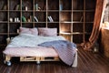 Modern bedroom in a loft. Urban apartment with pallet bed, scandinavian eco design. Royalty Free Stock Photo