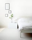 Modern bedroom with white bed, lamp and green ornamental and picture frame for mockup on wall with copy space. Royalty Free Stock Photo