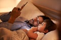 Modern bedtime story. A father reading a bedtime story to his son from an e-reader. Royalty Free Stock Photo