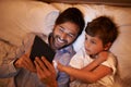 Modern bedtime story. A father reading a bedtime story to his son from an e-reader. Royalty Free Stock Photo