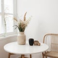 Modern beige ceramic vases with dry grass branches on white table near a black white wall backdrop. Copy space.Minimal Scandinavia