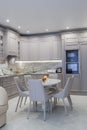 Modern beige and grey colored kitchen interior in classic style with dining table in luxury home