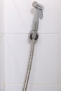 The modern bidet spray is hanging on the white tile wall Royalty Free Stock Photo