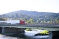 Modern big rig semi truck with semi trailer moving on the bridge Royalty Free Stock Photo