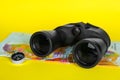 Modern binoculars, compass and map on yellow background, closeup Royalty Free Stock Photo