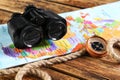 Modern binoculars, map, compass and rope on wooden table Royalty Free Stock Photo