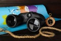 Modern binoculars, rope, compass and map on wooden table, closeup Royalty Free Stock Photo