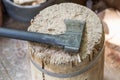 Modern black axe in the log and wooden chips after cutting firewood for winter near pile wooden house Royalty Free Stock Photo