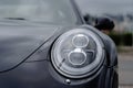 Modern black car xenon lamp headlight, front view close up. Modern car closeup of headlight Royalty Free Stock Photo